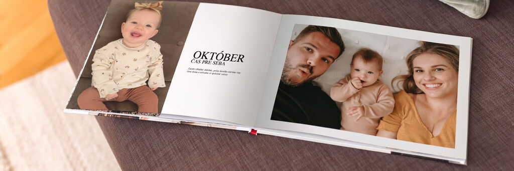Na hnedej pohovke leží otvorená kniha s fotografiami. Na ľavej dvojstrane je napísané "október".